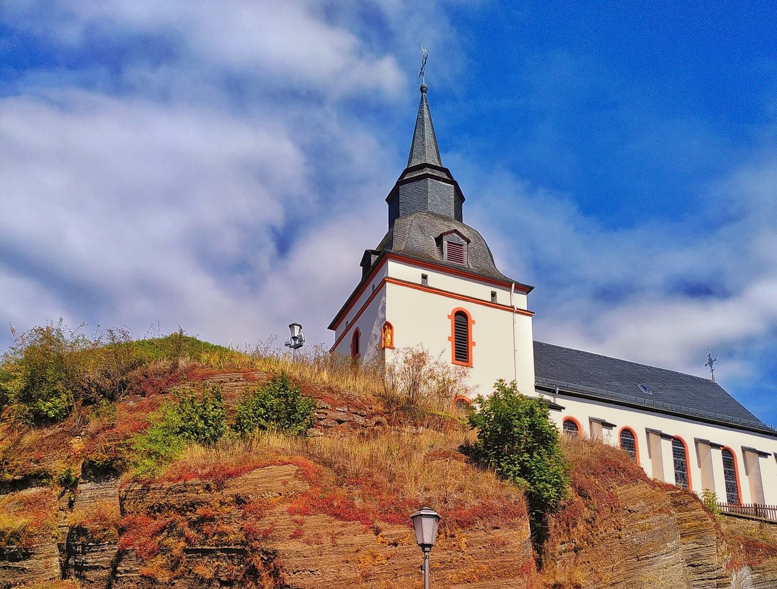 Kirche in Steffeln mit rotem Sandsteinfelsen - Lupe Reisen
